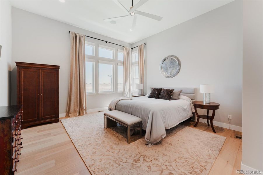 Twelve foot ceilings with windows stretching from floor to sky create a lofted, airy ambiance within the primary suite, perfectly positioned for optimal privacy.