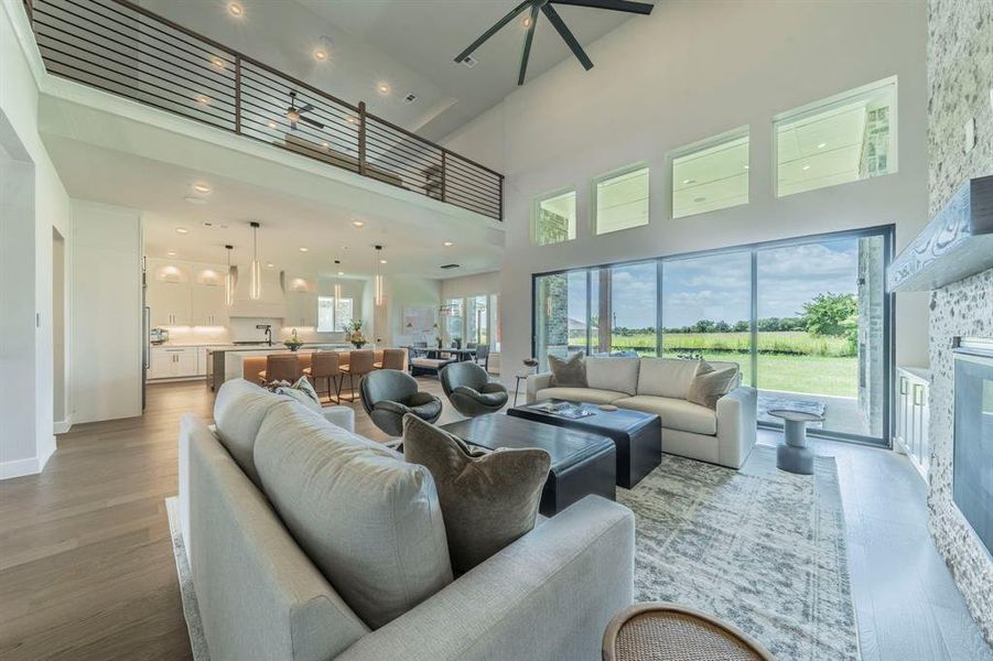 Living area featuring a towering ceiling, wood finished floors, and recessed lighting Living area featuring a towering ceiling, wood finished floors, and recessed lighting