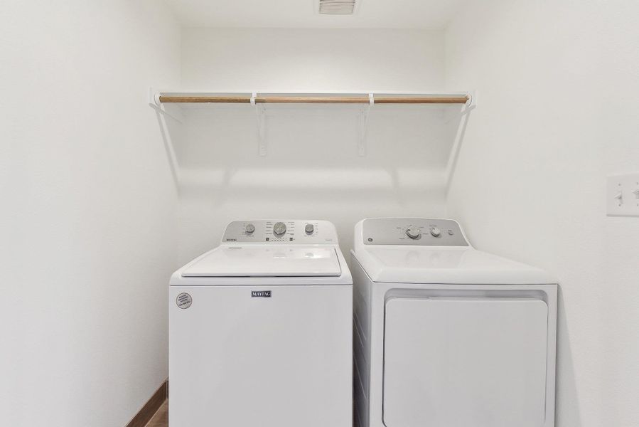 Clothes washing area with laundry area, separate washer and dryer, and baseboards
