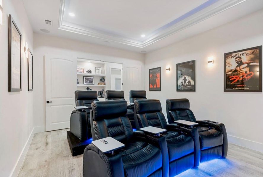 This media room comes with a tray ceiling, LED lights, wall sconces, and added surround sound for the best experience. There is a closet in the corner that is perfect for storing all your media equipment. Virtually Staged with owners furniture to show all the space even with 6 media chairs. This media room comes with a tray ceiling, LED lights, wall sconces, and added surround sound for the best experience. There is a closet in the corner that is perfect for storing all your media equipment. Virtually Staged with owners furniture to show all the space even with 6 media chairs.
