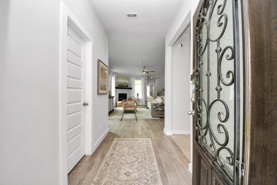 As you step into the threshold of this luxurious home, you'll soon be welcomed by an elegant glass door. Inside, soaring ceilings amplify the spaciousness, while the refined wood-look tile flooring and oversized baseboards exude sophistication and charm. Sample photo of completed home with similar floor plan. Actual colors and selections may vary.