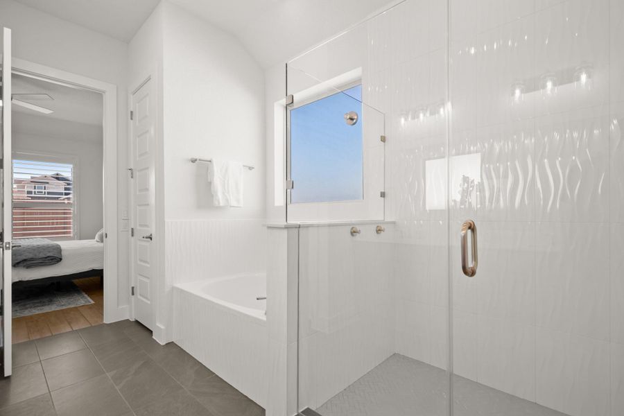 Ensuite bathroom featuring a bath, a stall shower, tile patterned flooring, and healthy amount of natural light