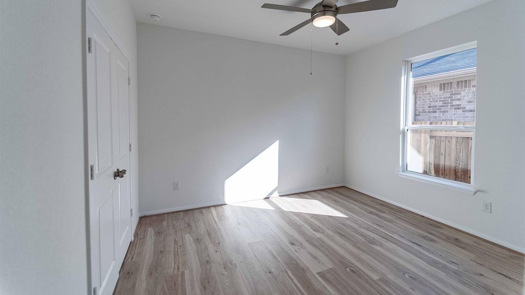 Unfurnished bedroom with light wood-type flooring, a ceiling fan, and a closet