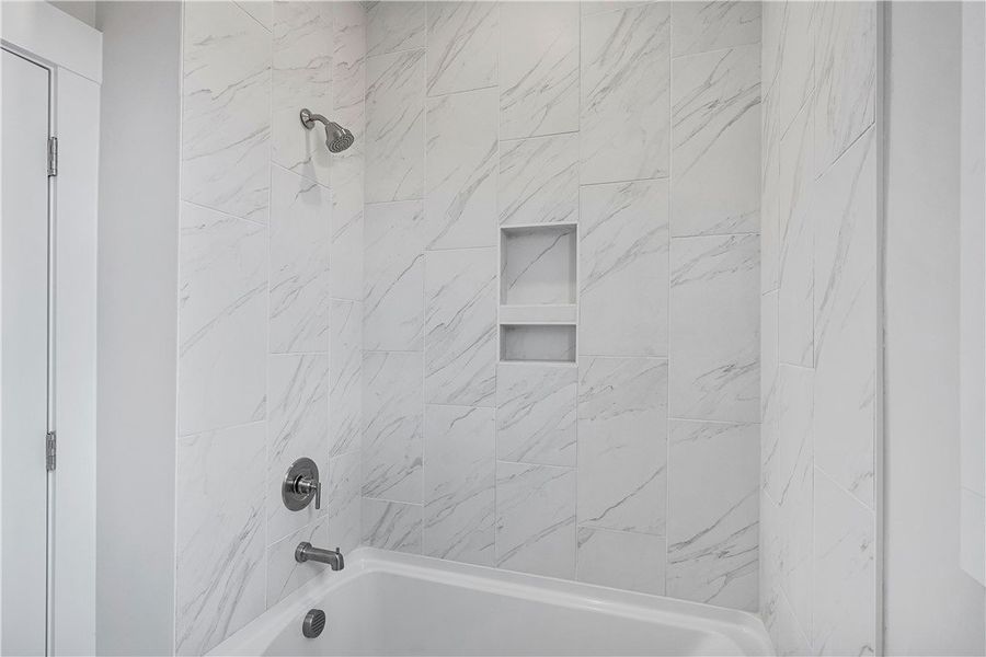 A pristine bath and shower combo features elegant A pristine bath and shower combo features elegant