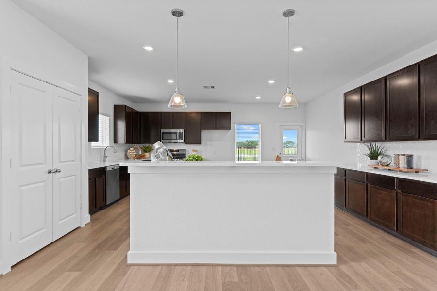 Gourmet kitchen features a large center island with pendant lighting, quartz countertops, and stylish dark cabinetry—perfect for prepping meals or gathering with family and friends. **Image Representative of Plan Only and May Vary as Built**. Gourmet kitchen features a large center island with pendant lighting, quartz countertops, and stylish dark cabinetry—perfect for prepping meals or gathering with family and friends. **Image Representative of Plan Only and May Vary as Built**.