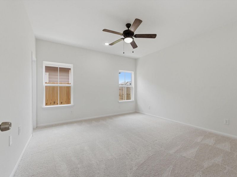 Conveniently located downstairs, the spacious primary suite offers a peaceful retreat with privacy, comfort, and easy access to the main living spaces.