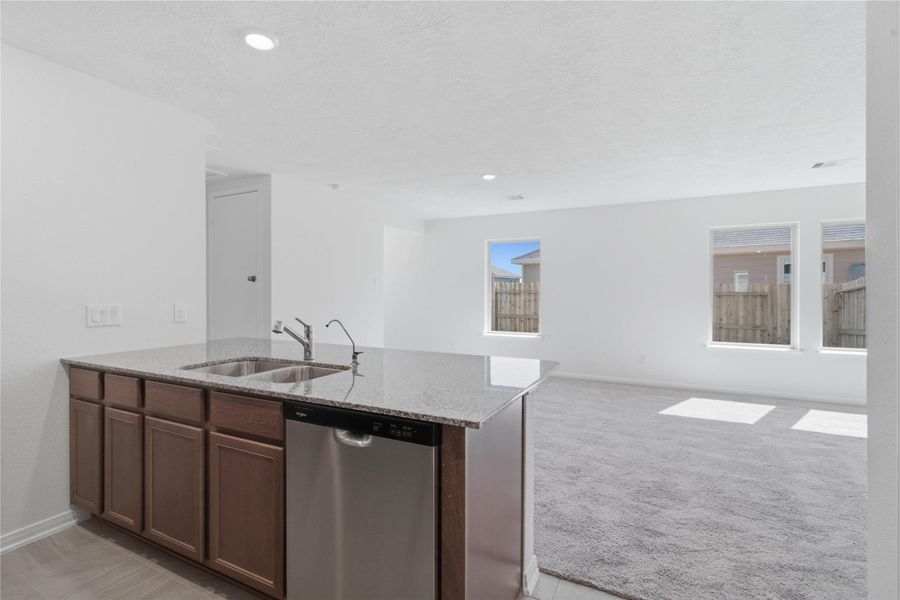 Start your day with a warm cup of coffee and quality time in this charming dining area! Highlights include a large window, custom neutral paint, carpet flooring, high ceilings, recessed lighting, and a convenient door leading to the rear patio and backyard.