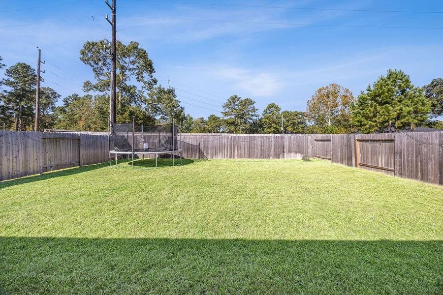 Expansive backyard featuring a trampoline, perfect for outdoor fun and relaxation. Expansive backyard featuring a trampoline, perfect for outdoor fun and relaxation.