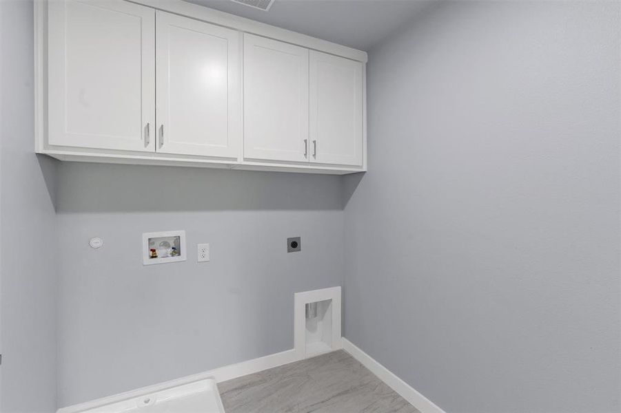 Laundry room featuring electric dryer hookup, washer hookup, cabinet space, and gas dryer hookup