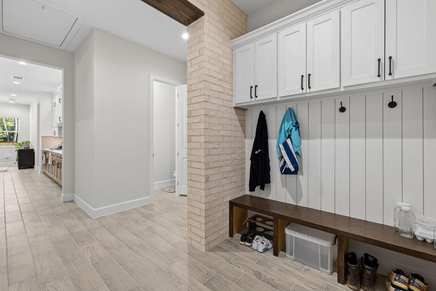 MUDROOM — Custom mudroom area features built-in cabinetry, bench seating, and dedicated storage conveniently positioned near the home’s garage entry.