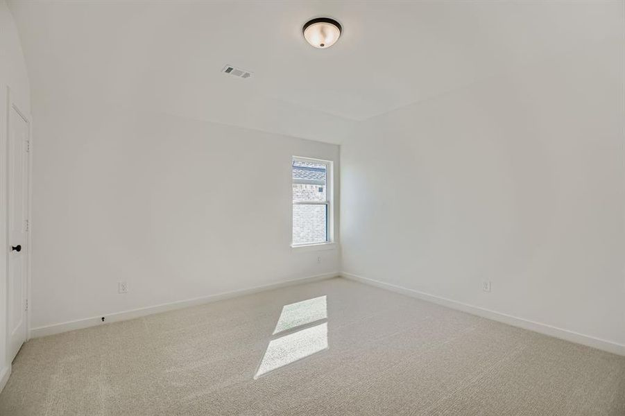 Spare room with light carpet and baseboards