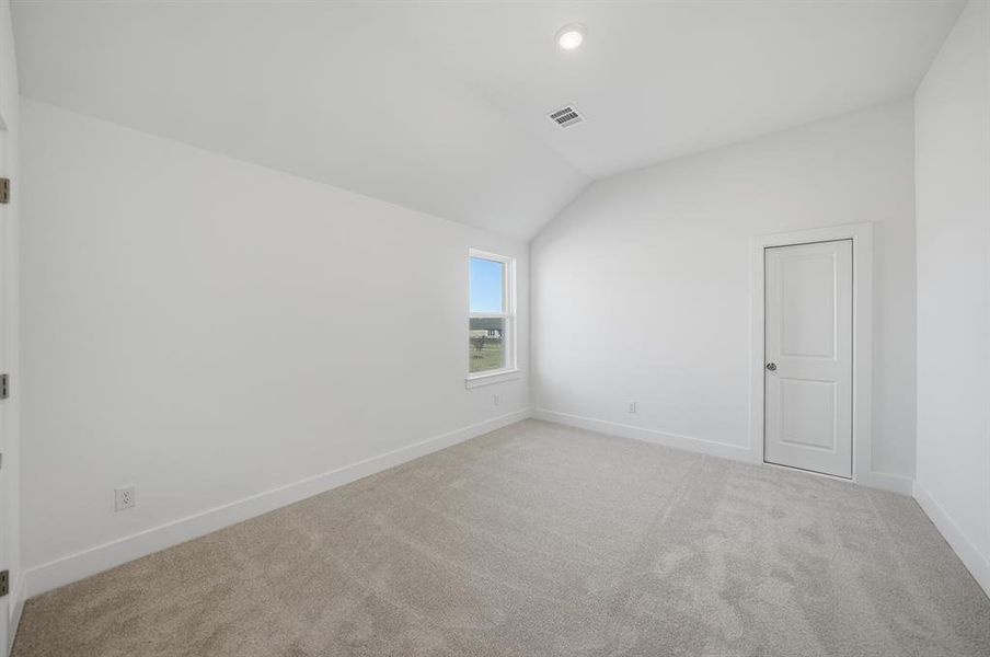 Unfurnished room with vaulted ceiling and light carpet Unfurnished room with vaulted ceiling and light carpet