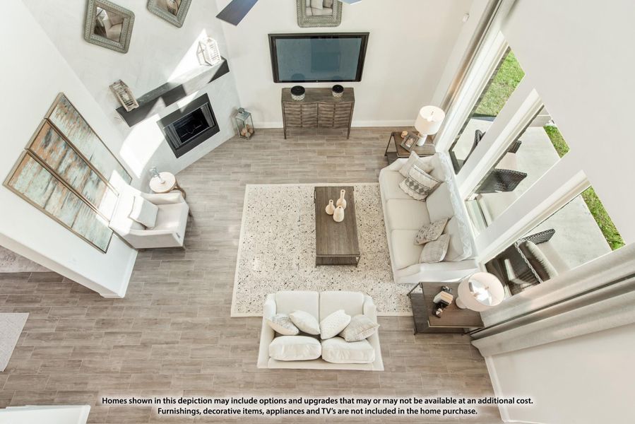 Overhead view of living room with vaulted ceiling, fireplace, wood-look floors, and neutral sectional seating