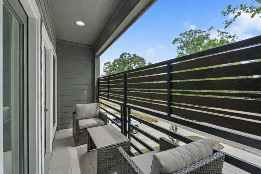 This exterior view from the upperbalcony shows the grayhorizontal siding and blackhorizontal railing, looking outtoward the street andsurrounding neighborhood.**Virtually staged