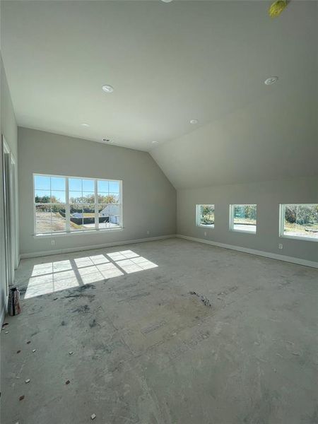 Additional living space with vaulted ceiling and baseboards