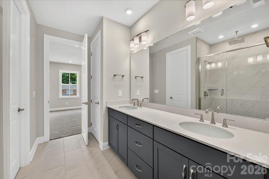 Dual vanity Primary bathroom with rich grey cabinets and white quartz countertops Dual vanity Primary bathroom with rich grey cabinets and white quartz countertops