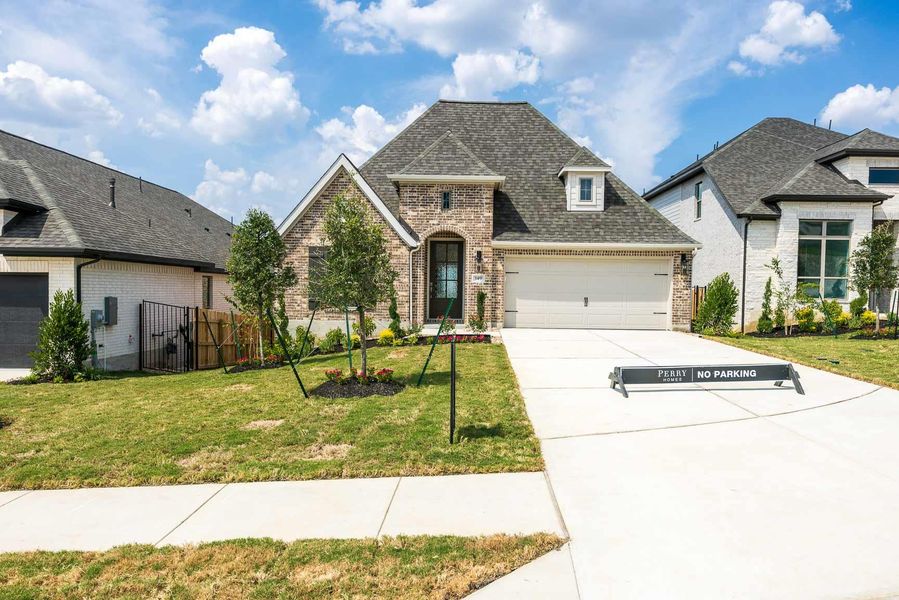French provincial home featuring brick siding, a shingled roof, concrete driveway, and an attached garage