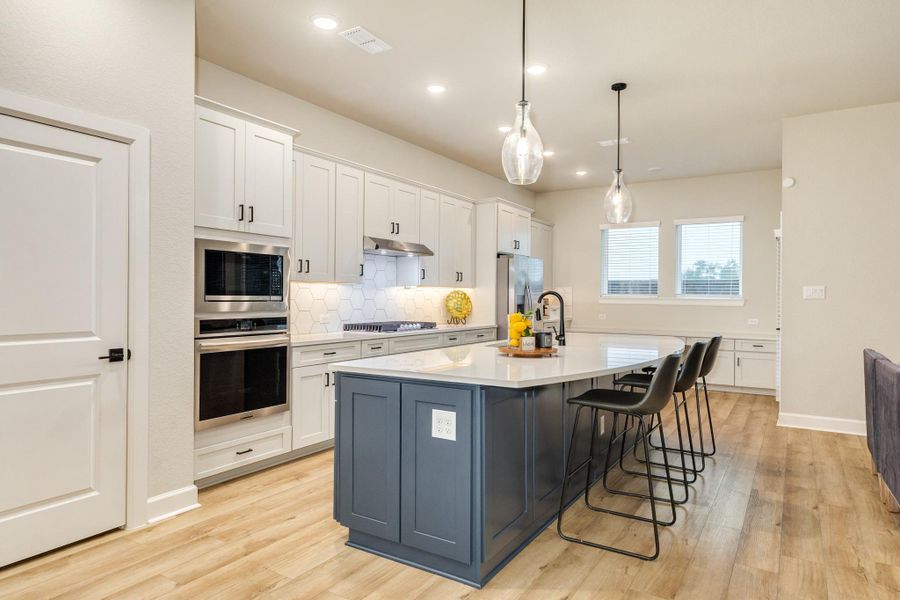 The beautiful light grey cabinets make the kitchen bright and spacious. Beautiful floors and great pendant lights make this an amazing space