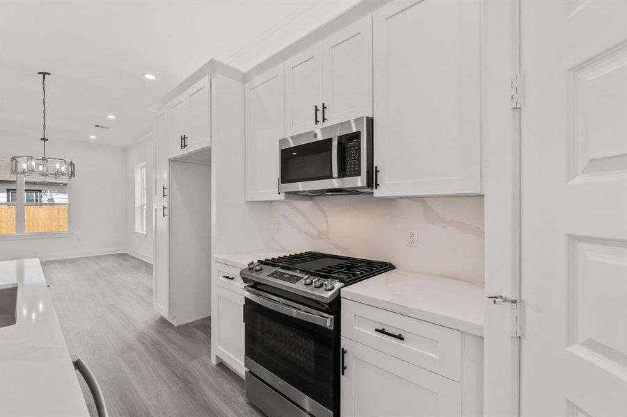 View from the kitchen showcasing the gas stove, microwave, and a glimpse of the living area