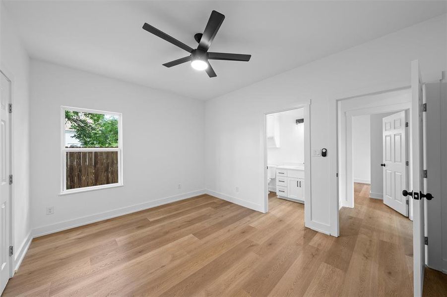 Unfurnished bedroom with light wood-style flooring, ensuite bathroom, and ceiling fan Unfurnished bedroom with light wood-style flooring, ensuite bathroom, and ceiling fan