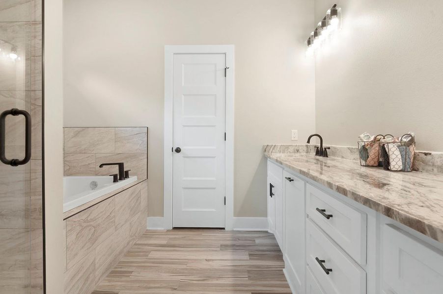 This bathroom features a modern design with a spacious vanity, marble countertops, and ample lighting. A sleek bathtub with stylish fixtures complements the neutral tile and flooring, creating a serene, elegant space. This bathroom features a modern design with a spacious vanity, marble countertops, and ample lighting. A sleek bathtub with stylish fixtures complements the neutral tile and flooring, creating a serene, elegant space.