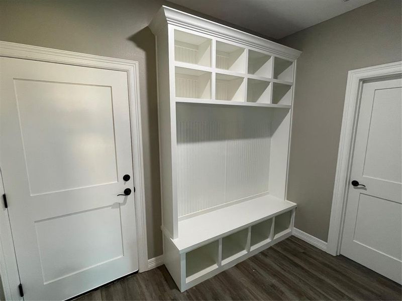 Mudroom featuring baseboards and dark wood-type flooring