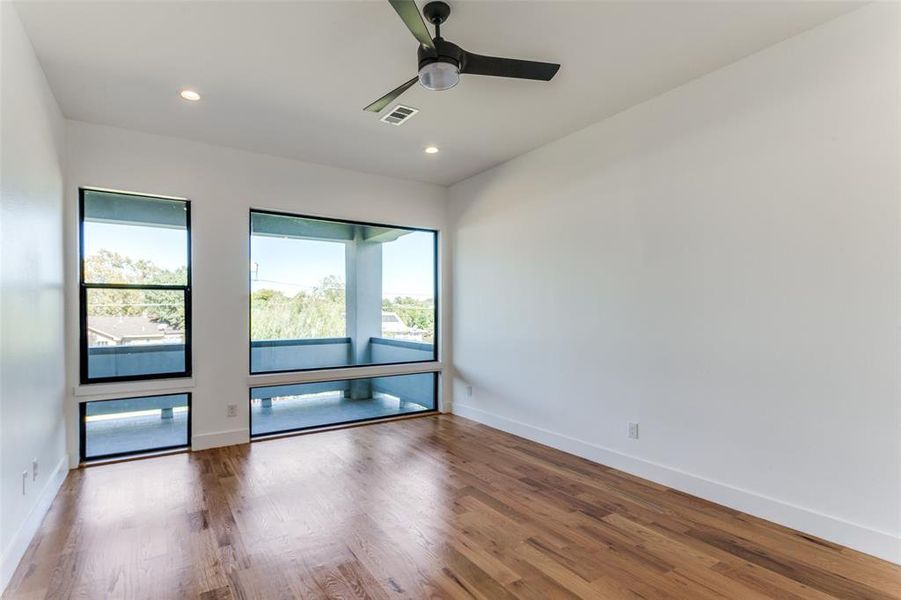 Empty room featuring hardwood / wood-style flooring and ceiling fan