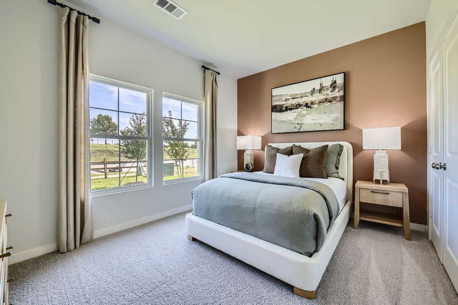 A bedroom with a large window. A bedroom with a large window.