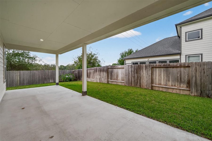 The covered patio at the back provides a comfortable space for relaxing and spending time outdoors.