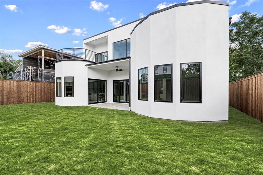 Rear view of property featuring a balcony, stucco siding, and ceiling fan Rear view of property featuring a balcony, stucco siding, and ceiling fan