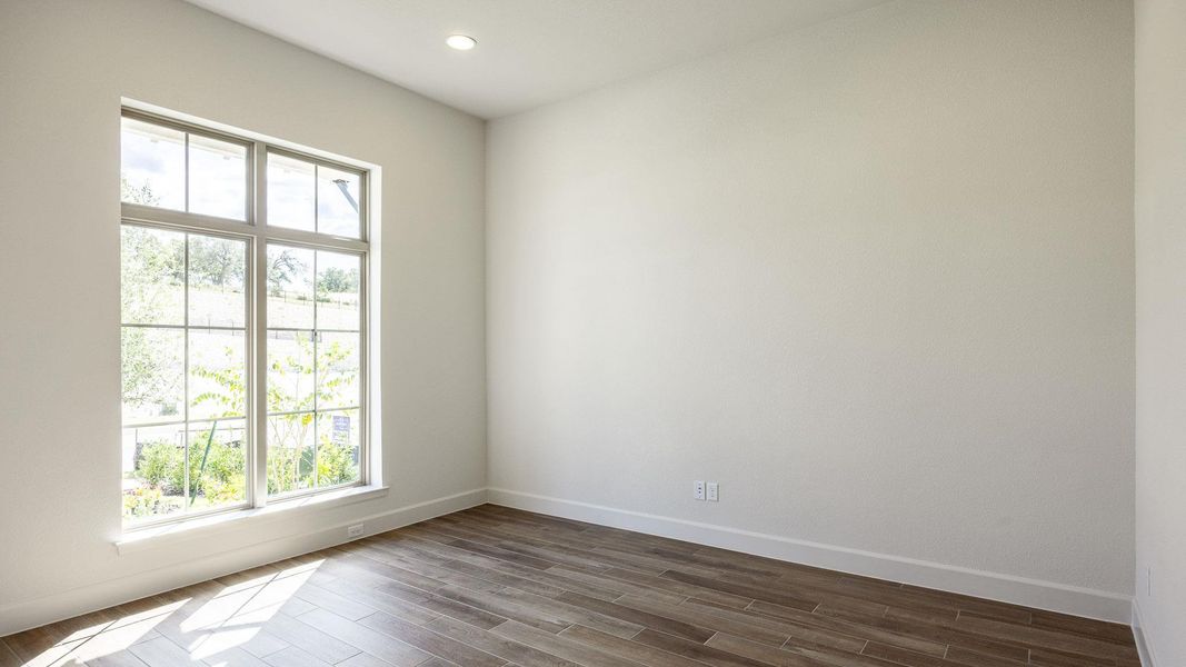 Empty room with wood finished floors and recessed lighting Empty room with wood finished floors and recessed lighting