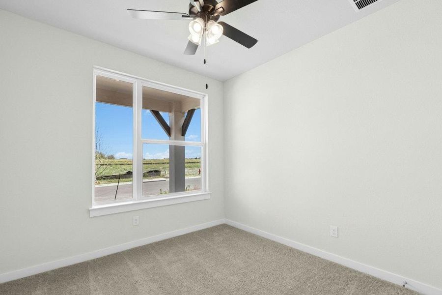 Carpeted empty room featuring baseboards and ceiling fan