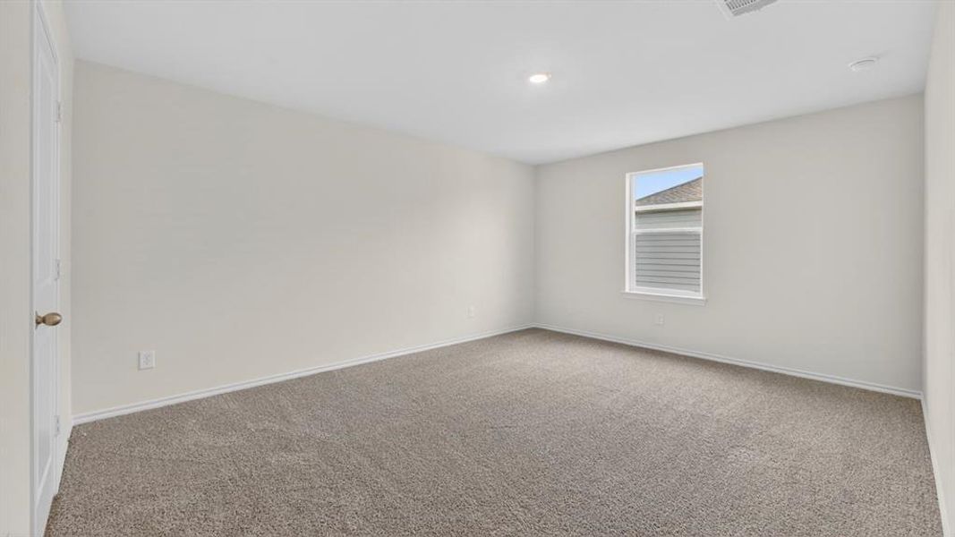 Spacious room featuring neutral carpeting, light-toned walls, and a single window