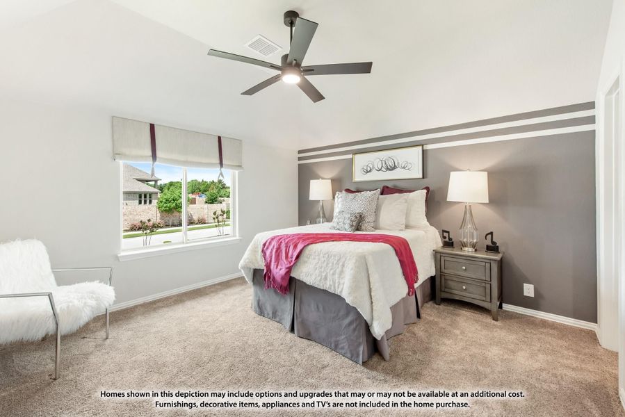 Bedroom with vaulted ceiling, ceiling fan, gray accent wall, and carpet flooring
