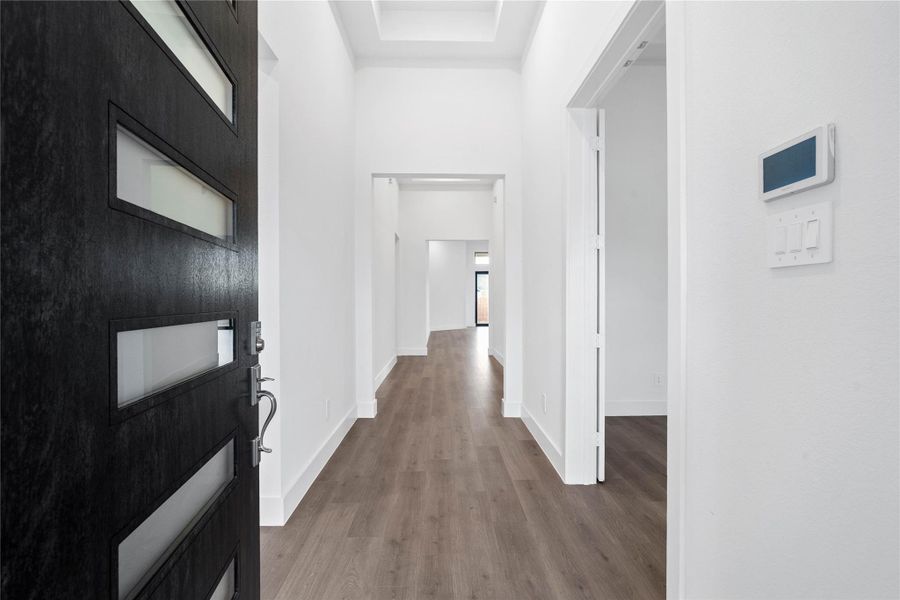 An inviting entrance opens up to an open-concept layout, seamlessly connecting the entry to the study and Great Room with durable laminate flooring and striking architectural details.