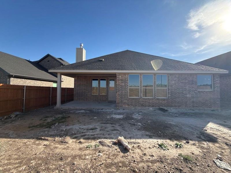 Rear view of property with a patio area, brick siding, a fenced backyard, and a chimney