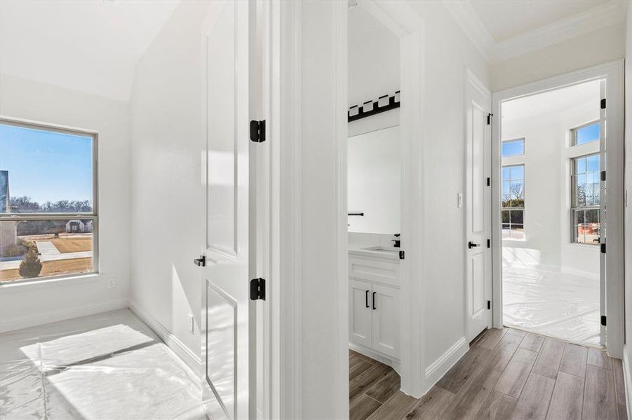 Hall featuring a wealth of natural light and ornamental molding.