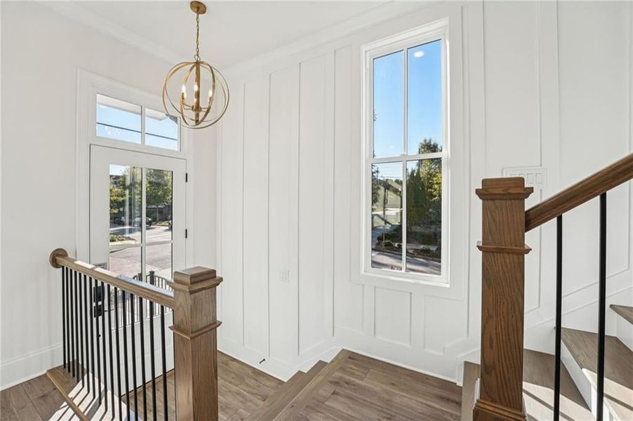 Stairway featuring wood finished floors and a chandelier Stairway featuring wood finished floors and a chandelier
