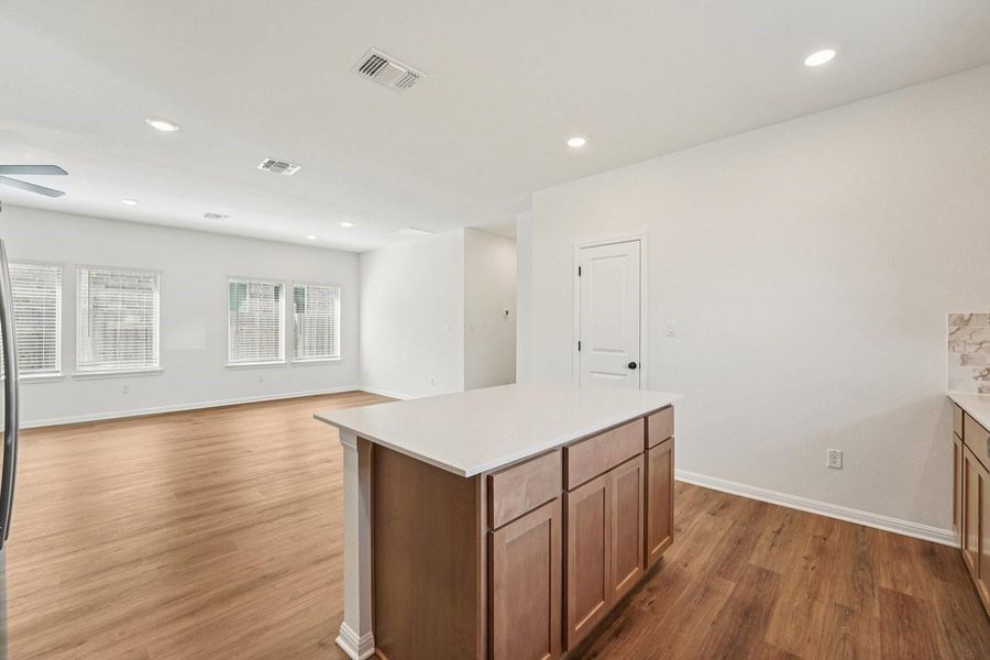 A streamlined kitchen island grounds an airy open-concept living area with abundant natural light. A streamlined kitchen island grounds an airy open-concept living area with abundant natural light.