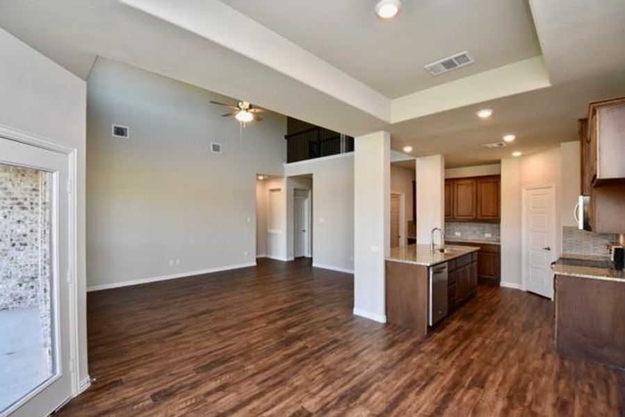 Kitchen featuring open floor plan, light stone counters, ceiling fan, tasteful backsplash, and recessed lighting Kitchen featuring open floor plan, light stone counters, ceiling fan, tasteful backsplash, and recessed lighting