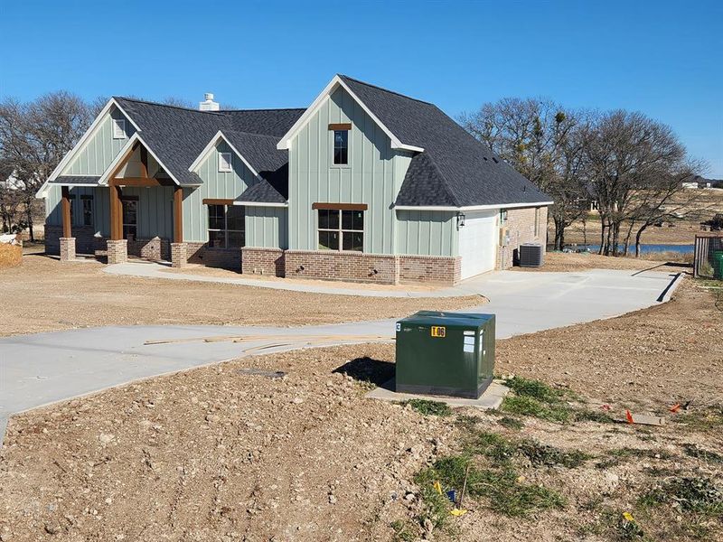 View of front of home featuring a garage and cooling unit