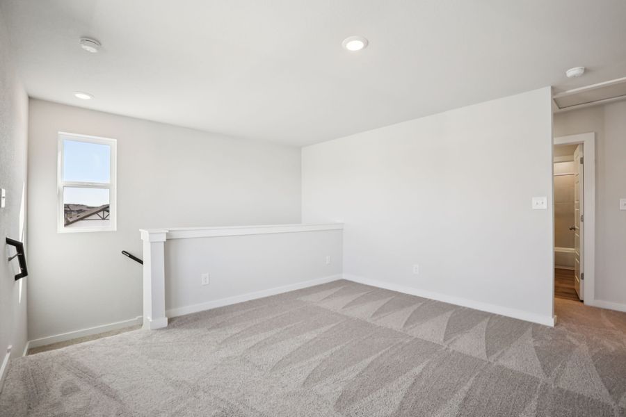 A room with a carpet and a white wall.