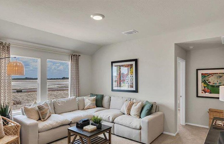 Living area featuring light colored carpet, lofted ceiling, and baseboards Living area featuring light colored carpet, lofted ceiling, and baseboards