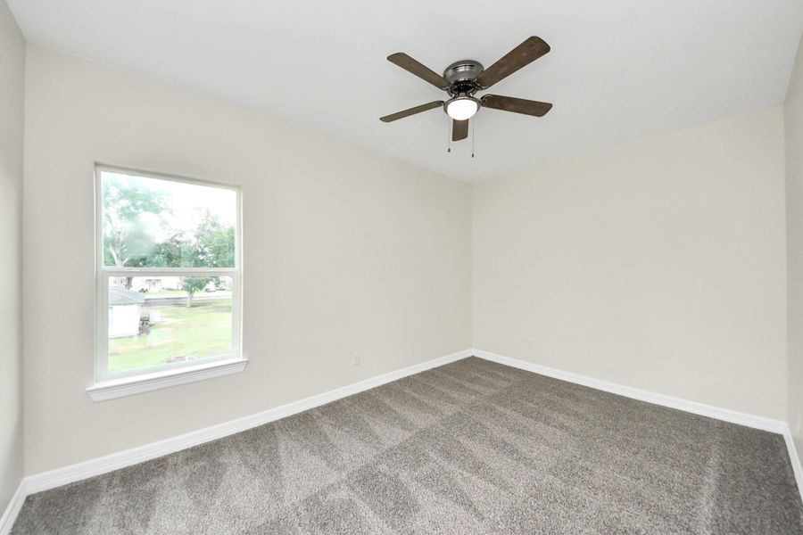 This cozy oversized secondary bedroom exudes warmth with a large window that fills the space with natural light, neutral-toned walls, a spacious closet for ample storage, and plush carpeting for added comfort  - (representation photo).
