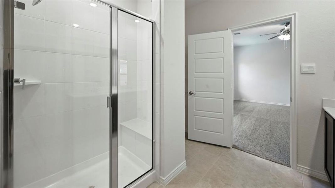 Bathroom with vanity, a stall shower, a ceiling fan, light colored carpet, and light tile patterned floors