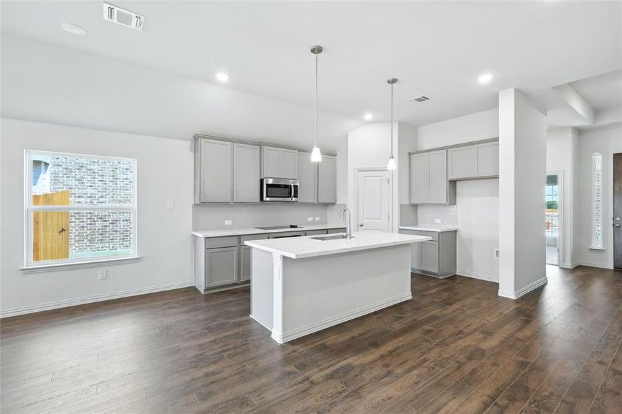 Kitchen with gray cabinets, hanging light fixtures, a kitchen island with sink, dark wood finished floors, and recessed lighting Kitchen with gray cabinets, hanging light fixtures, a kitchen island with sink, dark wood finished floors, and recessed lighting