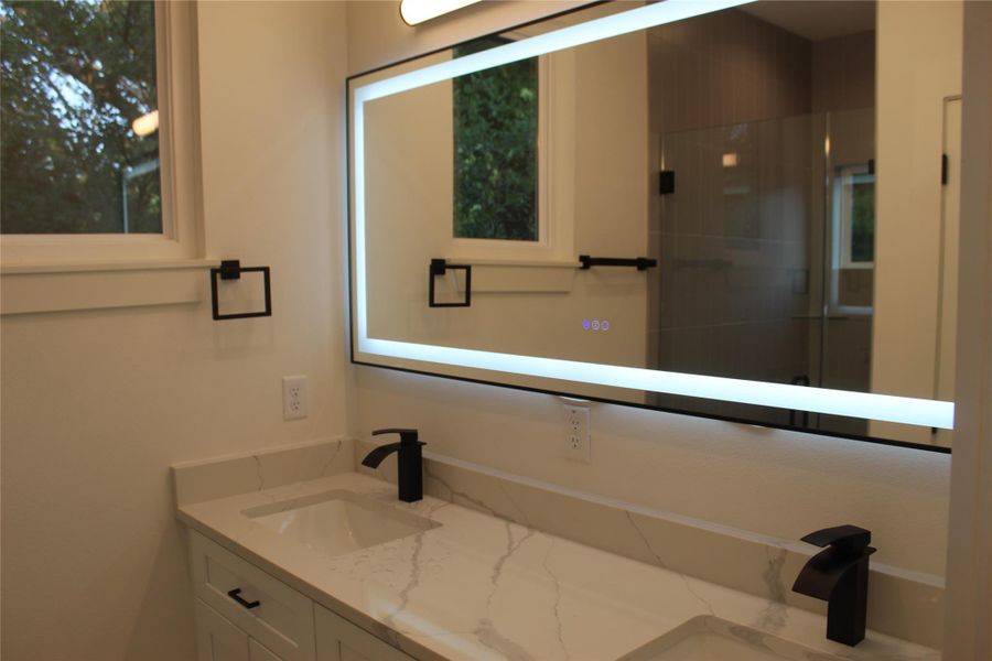 A well-lit, functional bathroom features a dual vanity with ample counter space and modern fixtures.