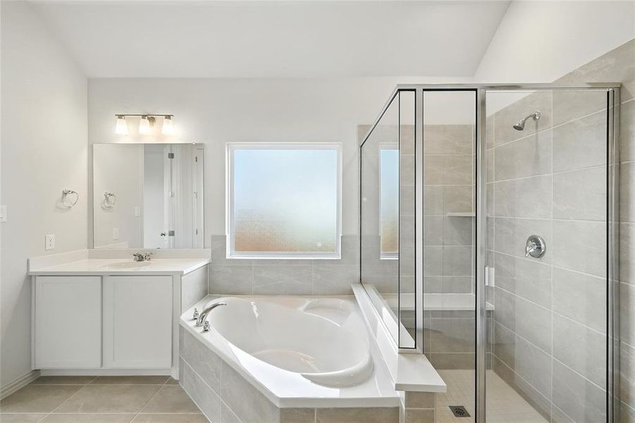 Bathroom featuring a shower stall, vanity, a garden tub, and light tile patterned floors