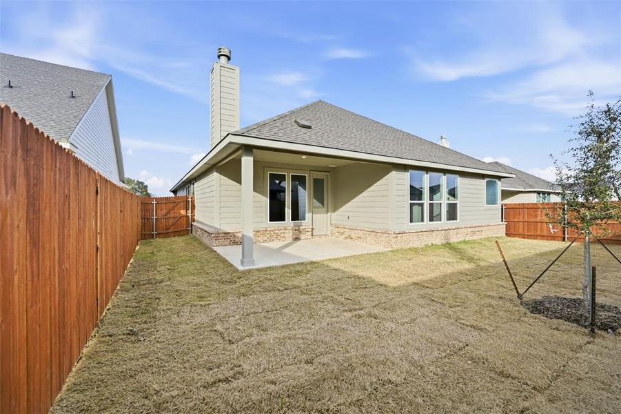 Rear view of property with a shingled roof, a patio, a fenced backyard, and a chimney
