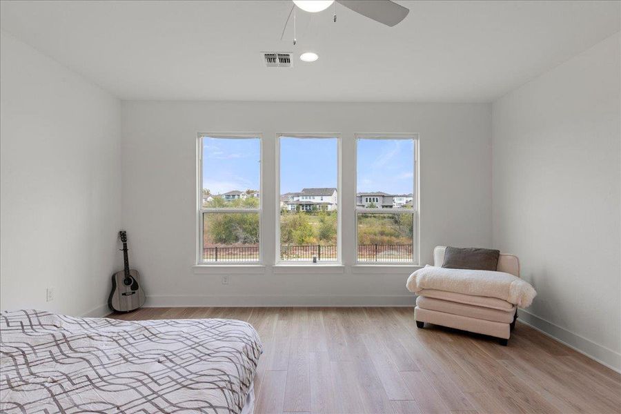 Bedroom with light wood-style flooring, multiple windows, a ceiling fan, and recessed lighting Bedroom with light wood-style flooring, multiple windows, a ceiling fan, and recessed lighting